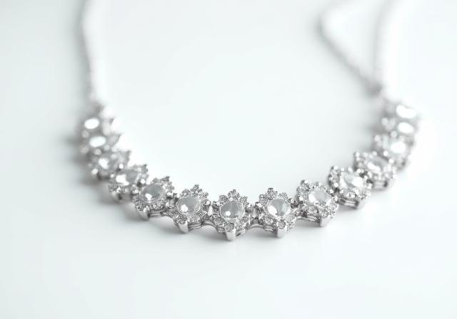 Close-up product shot of a sparkling silver necklace on a white background